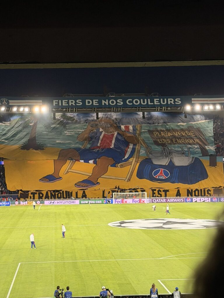 Collectif Ultras Paris display a giant Luis Enrique beach-themed tifo before PSG vs Slovan Bratislava